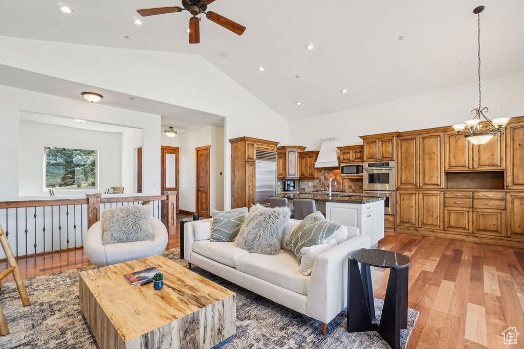 Living area featuring light wood finished floors, recessed lighting, ceiling fan, and high vaulted ceiling