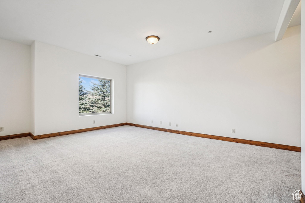 Spare room with light carpet and baseboards
