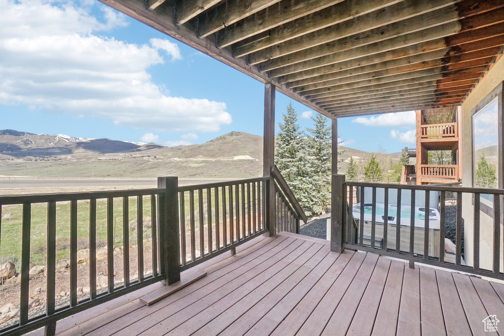Deck with a mountain view and a jacuzzi