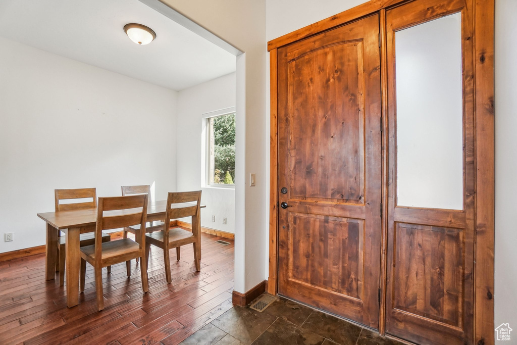 Dining space with baseboards, dark wood-style floors, and visible vents