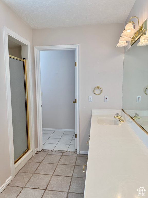 Bathroom with vanity, tile patterned floors, and a shower stall