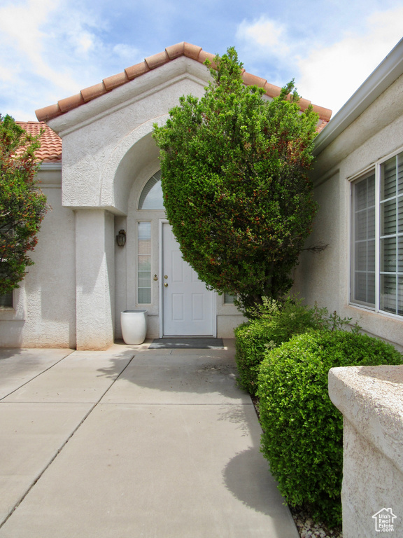 Entrance to property with stucco siding and a tiled roof