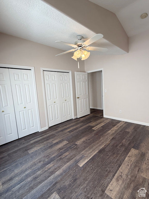 Unfurnished bedroom with baseboards, a ceiling fan, two closets, and wood finished floors