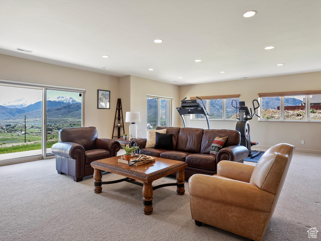Carpeted living room featuring a wealth of natural light, visible vents, recessed lighting, and a mountain view