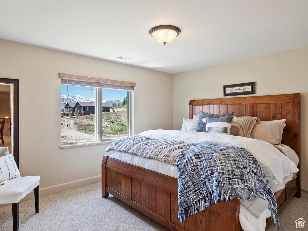 Carpeted bedroom featuring baseboards and visible vents