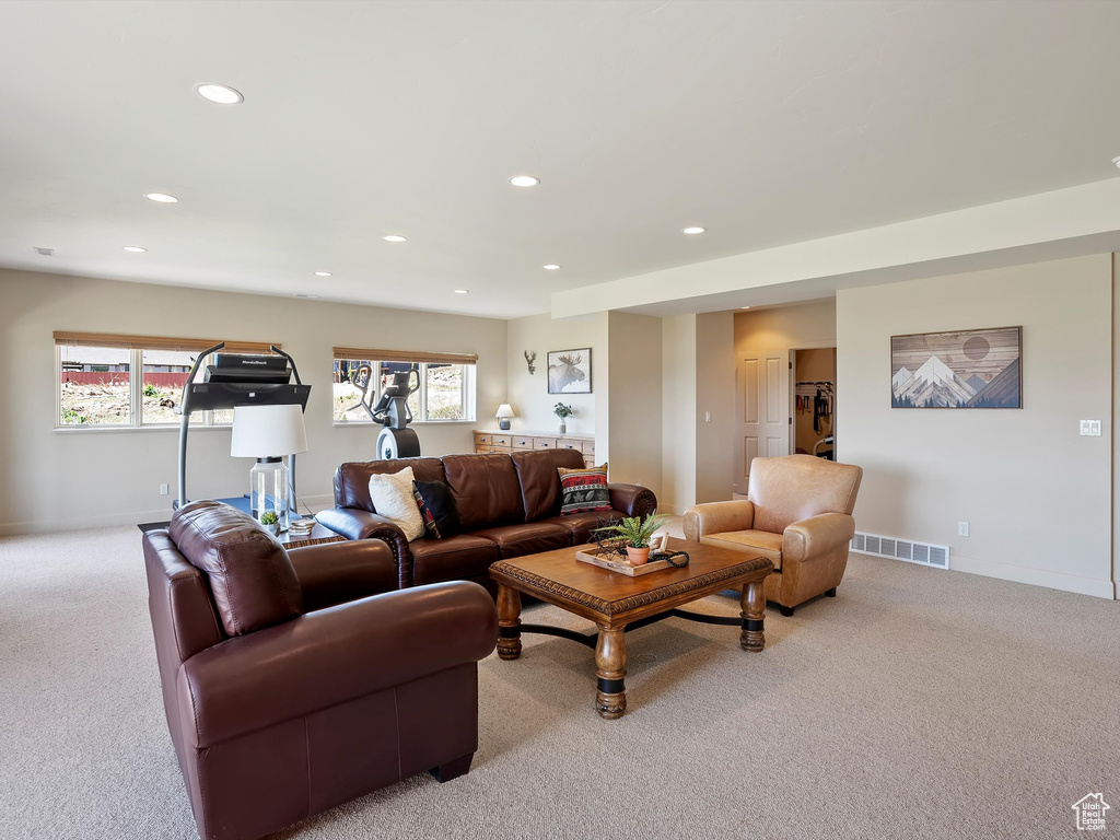 Living area with light colored carpet, baseboards, visible vents, and recessed lighting