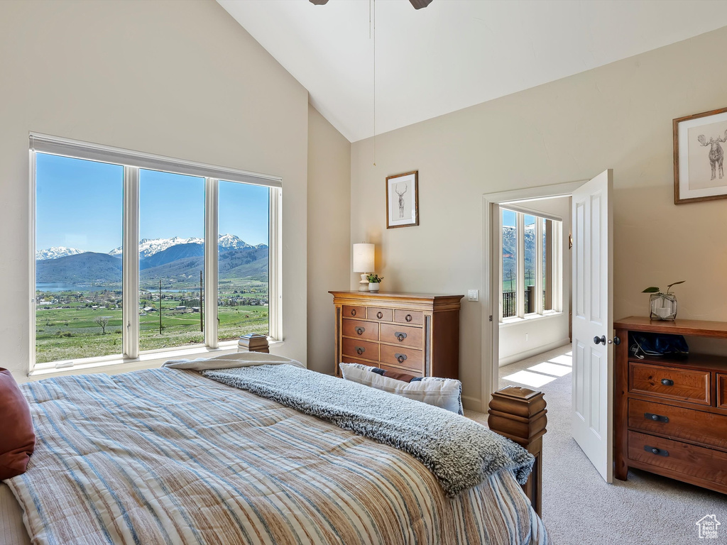 Carpeted bedroom featuring a mountain view and high vaulted ceiling