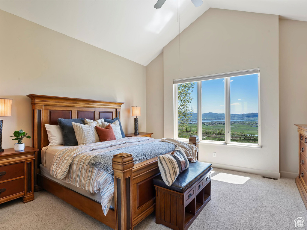 Bedroom featuring high vaulted ceiling, visible vents, light carpet, a ceiling fan, and baseboards