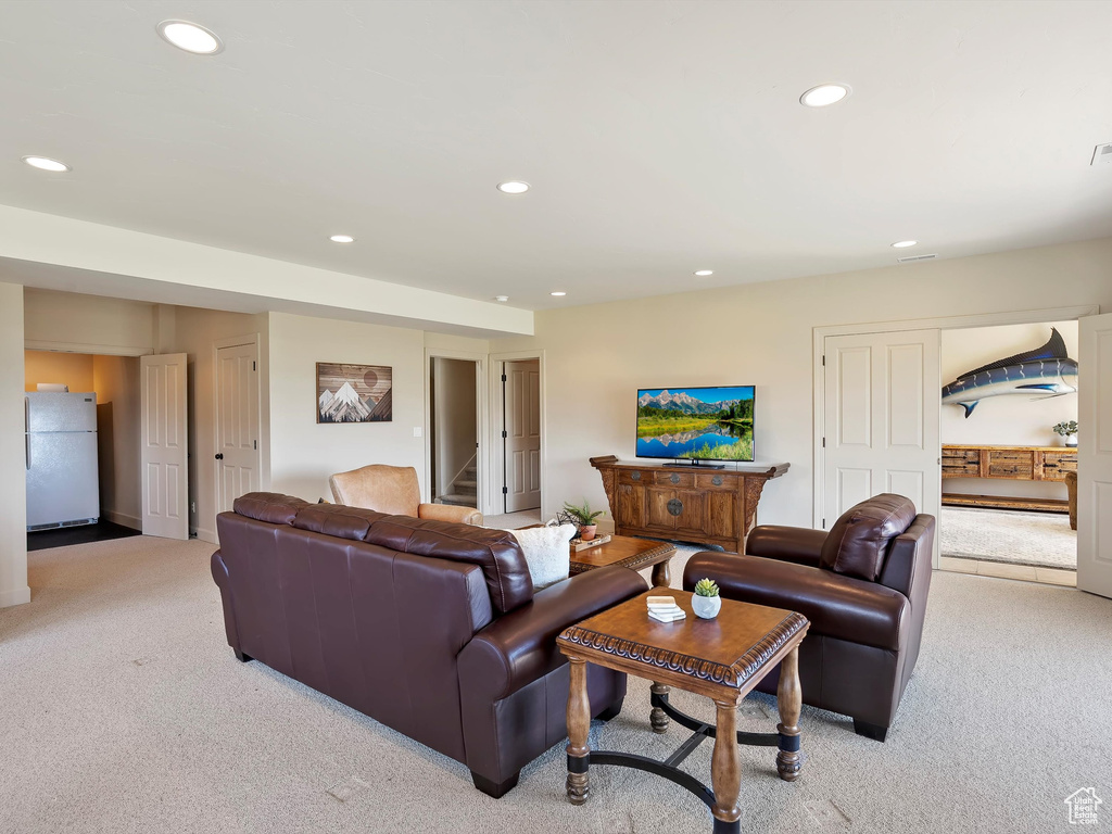 Living room featuring stairway, recessed lighting, and light colored carpet