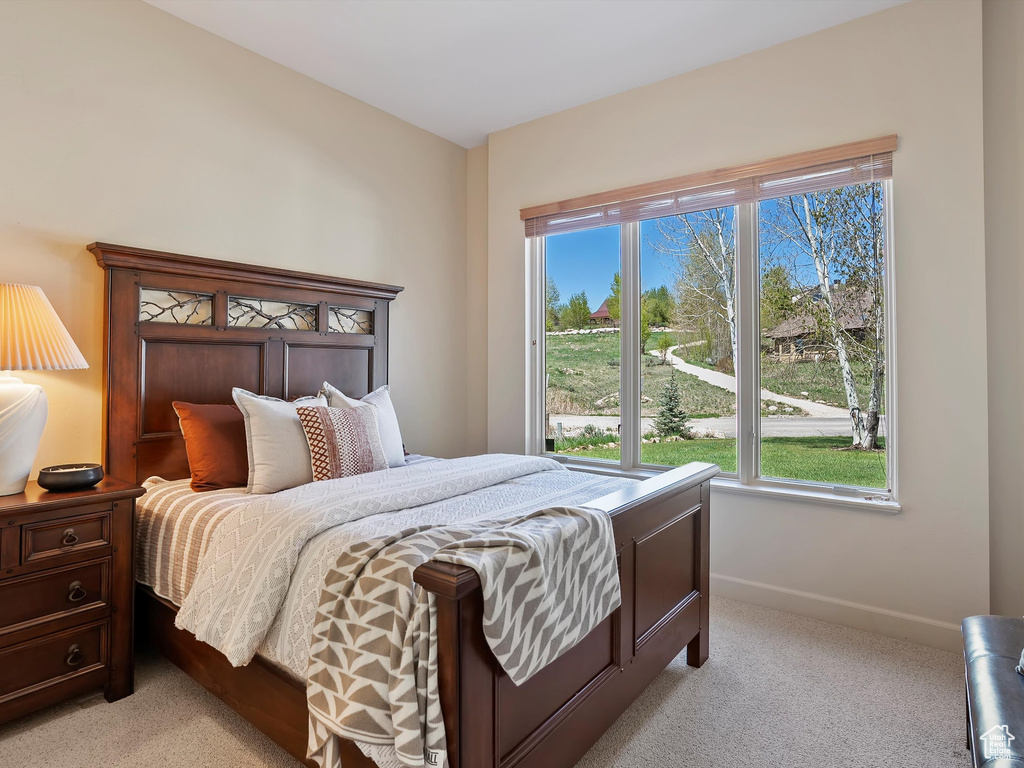 Bedroom with light colored carpet and baseboards