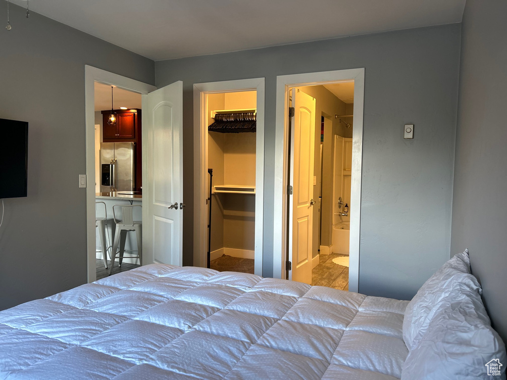 Bedroom with a closet, ensuite bath, stainless steel fridge, and a spacious closet