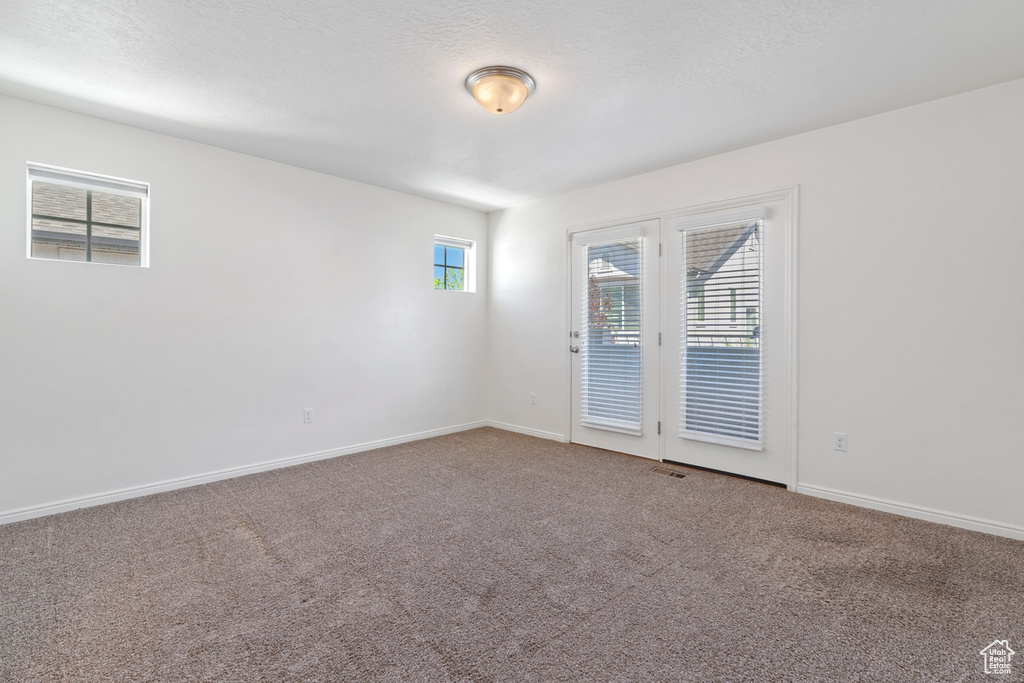 Carpeted spare room with baseboards