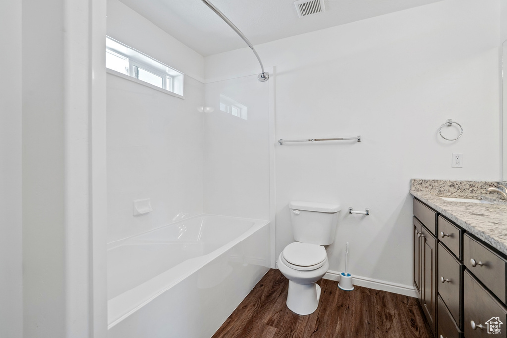 Bathroom featuring toilet, wood finished floors, visible vents, baseboards, and vanity