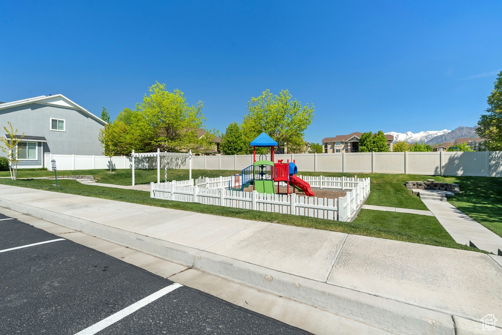 Community jungle gym featuring a yard and fence