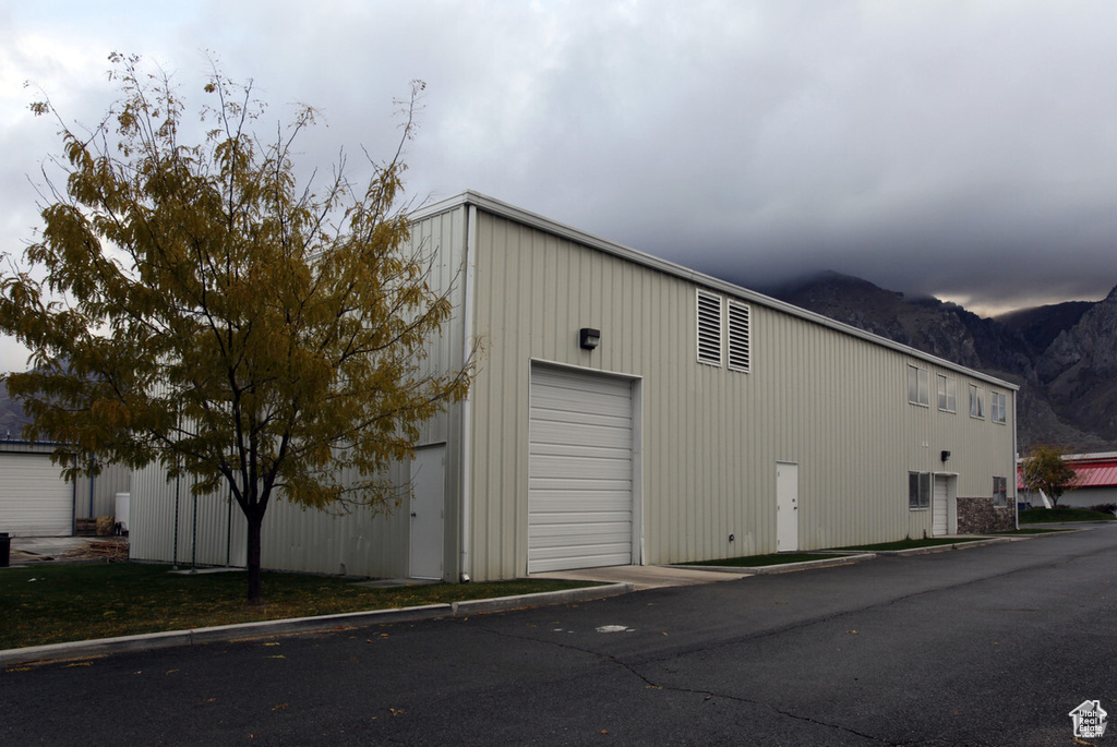 View of property exterior with a mountain view and a detached garage