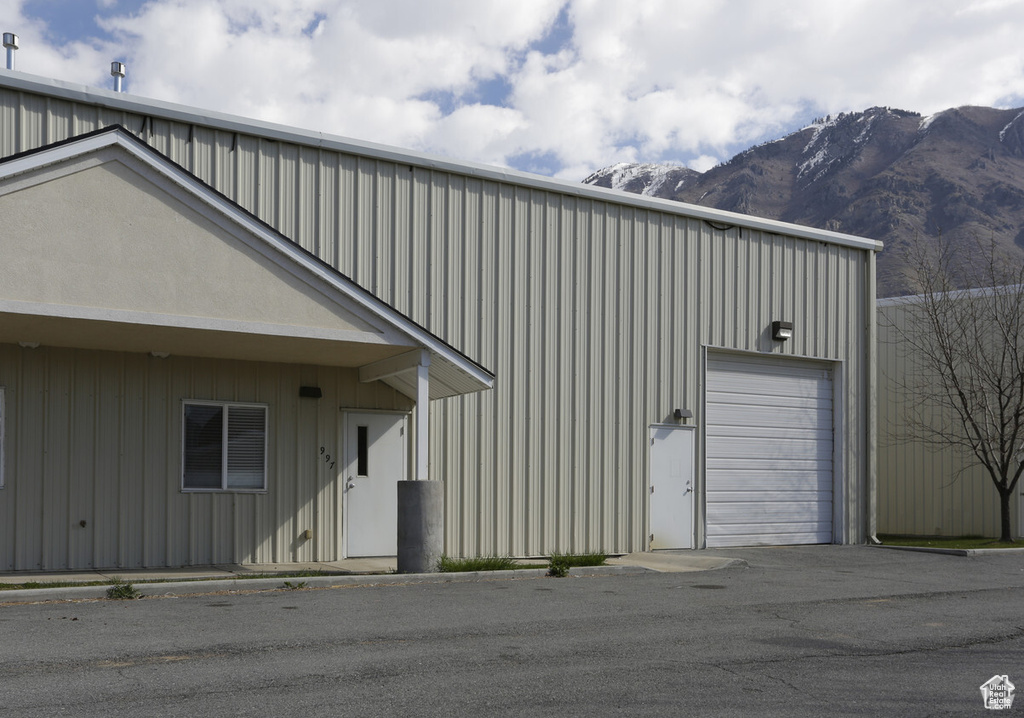 Exterior space featuring a mountain view, an outbuilding, a garage, and board and batten siding