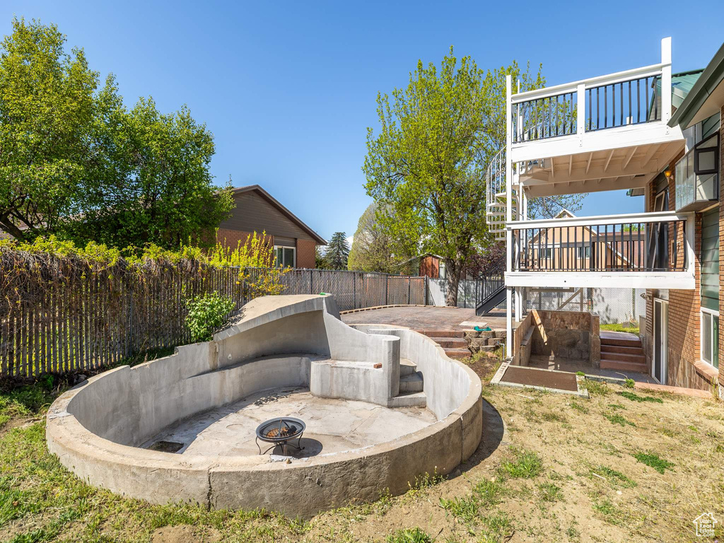 View of yard with a fenced backyard, stairs, a fire pit, and a deck