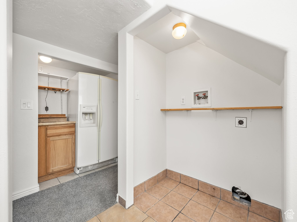 Clothes washing area with baseboards, light tile patterned floors, hookup for an electric dryer, and washer hookup