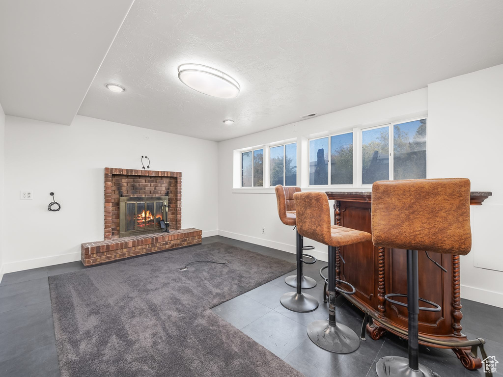 Bar featuring baseboards, a dry bar, and a brick fireplace