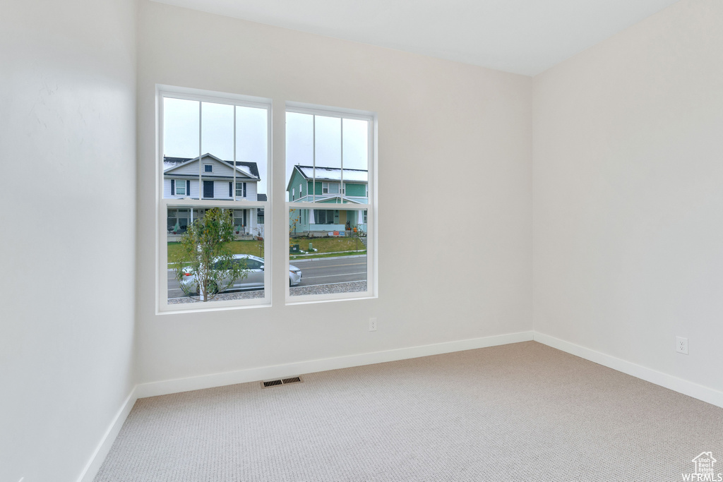 Spare room with carpet, baseboards, and visible vents