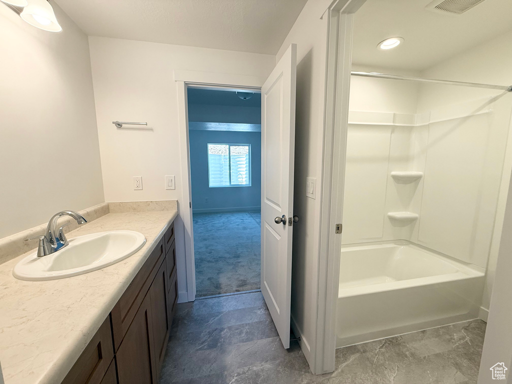 Bathroom featuring vanity, tub / shower combination, baseboards, and visible vents