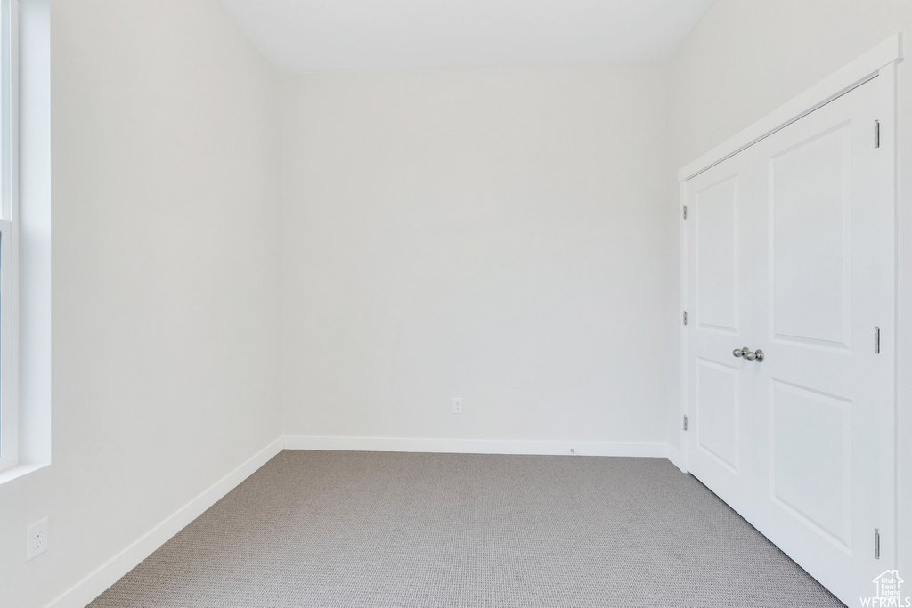 Carpeted empty room with baseboards