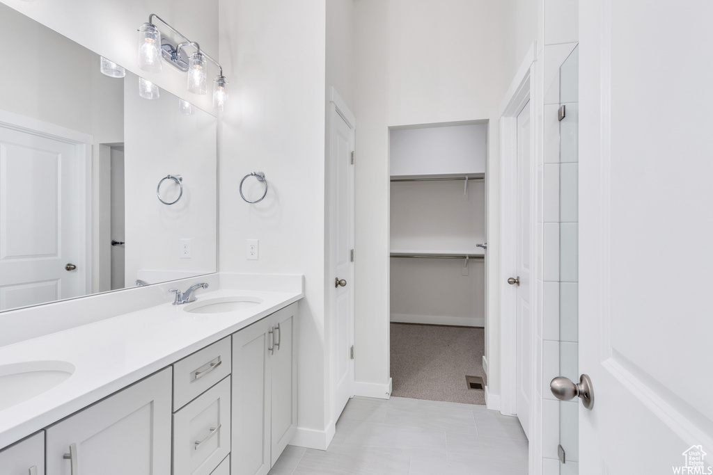 Full bathroom featuring a sink, double vanity, baseboards, and visible vents