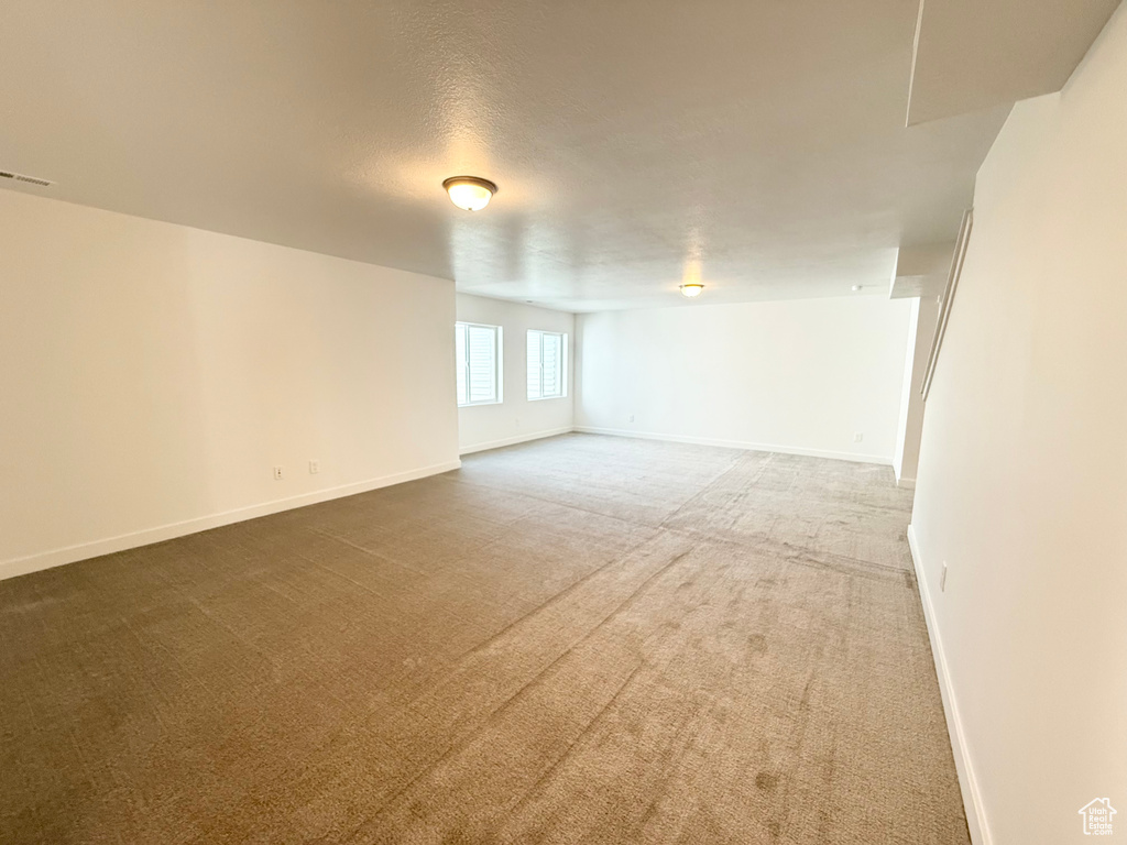 Spare room featuring baseboards and carpet floors