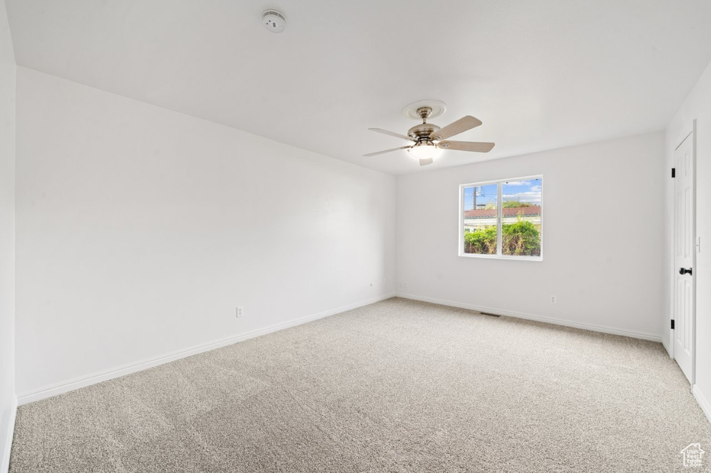 Unfurnished bedroom with light carpet, baseboards, visible vents, and ceiling fan