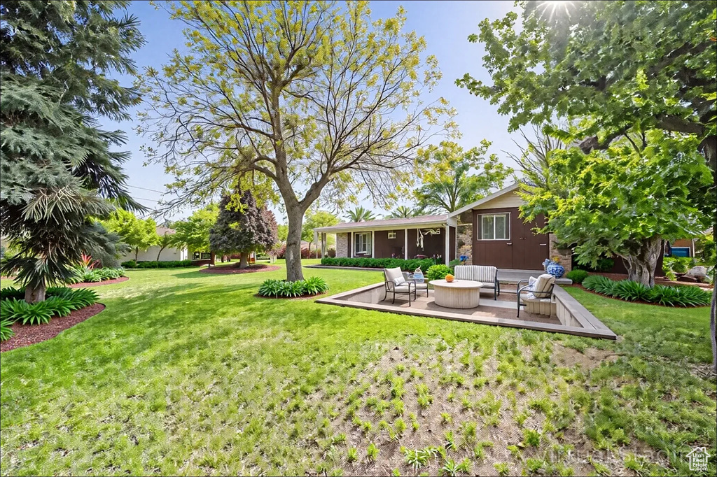 View of grassy yard with an outdoor hangout area and a patio area