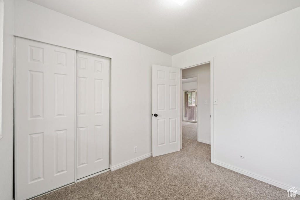 Unfurnished bedroom with carpet flooring, baseboards, and a closet