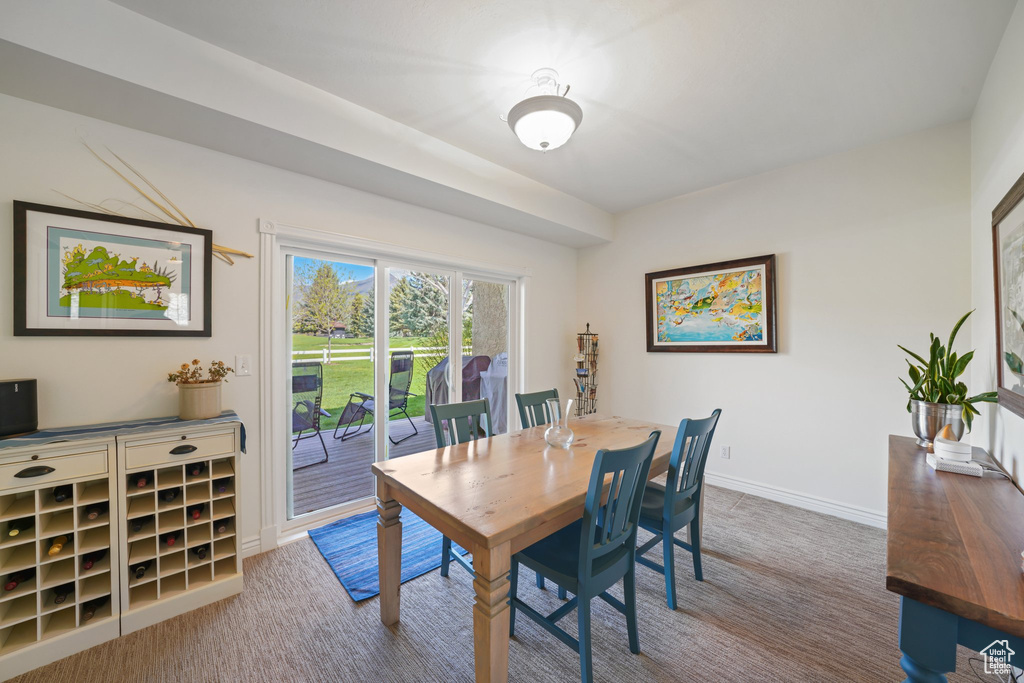 Carpeted dining space with baseboards