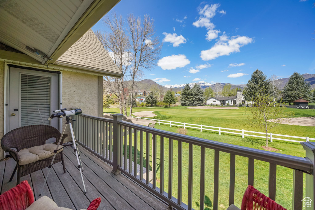 Deck featuring a lawn, a fenced backyard, a mountain view, and golf course view