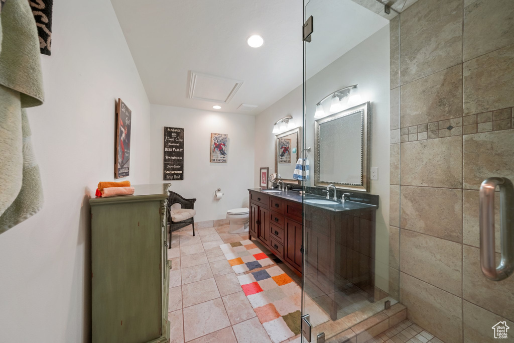 Bathroom featuring double vanity, tile patterned floors, recessed lighting, and a sink