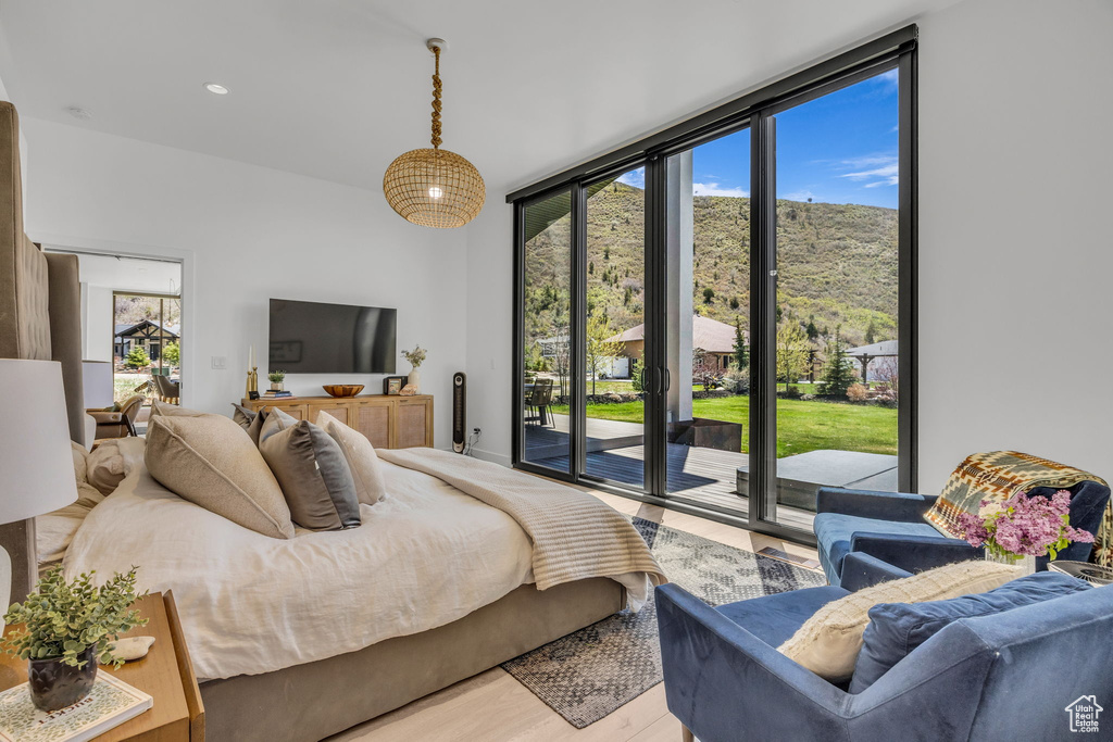Bedroom with access to outside, wood finished floors, and expansive windows