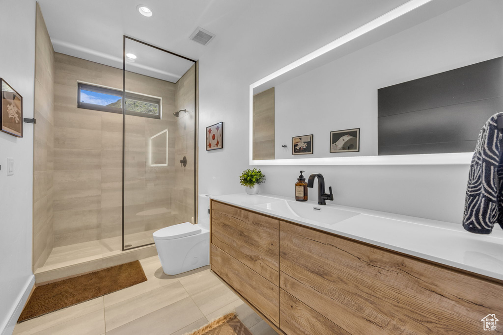 Full bath featuring toilet, tiled shower, vanity, tile patterned flooring, and recessed lighting