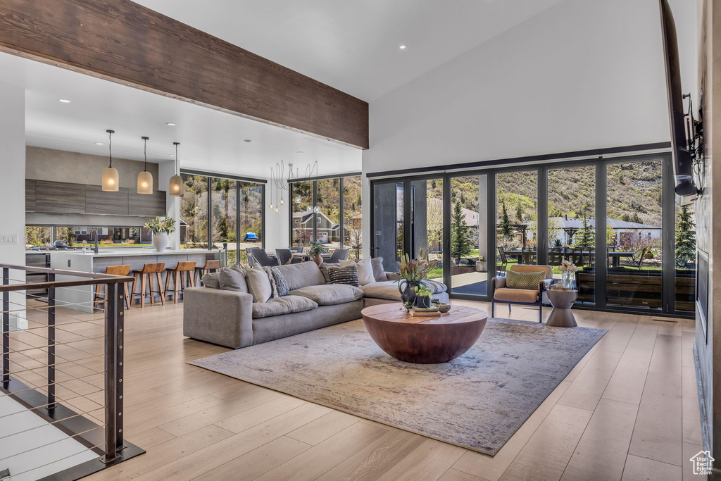 Living room with a towering ceiling, recessed lighting, and wood-type flooring