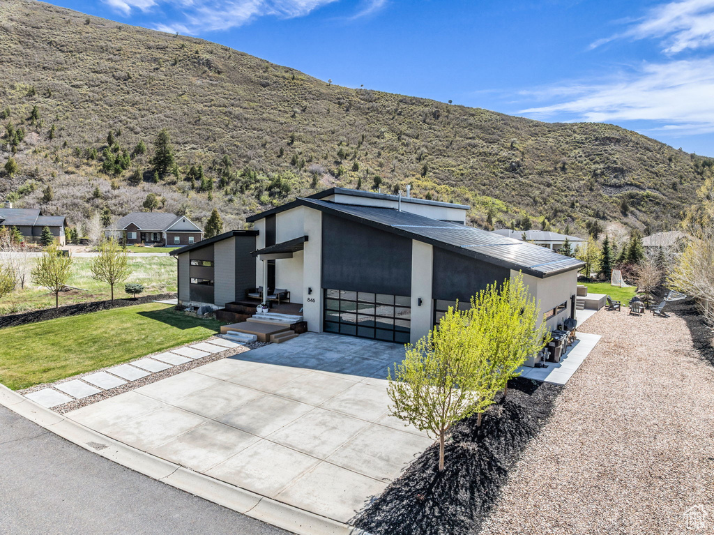 Garage featuring concrete driveway and a mountain view