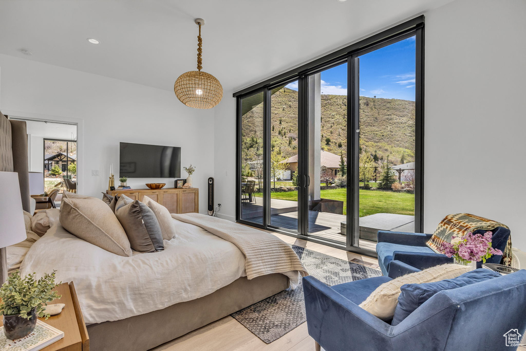 Bedroom featuring access to exterior, expansive windows, light wood-style floors, and recessed lighting