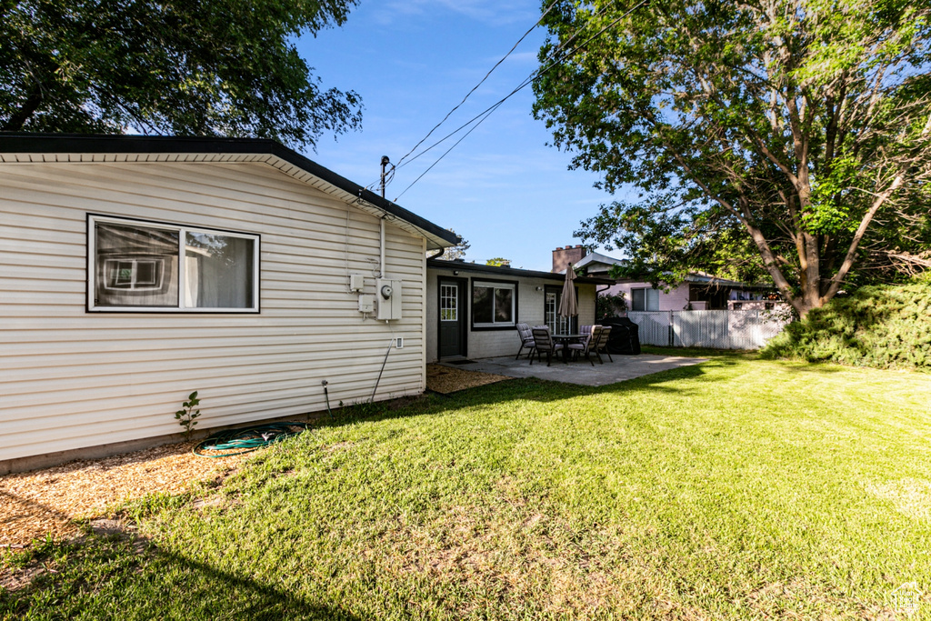 Back of house with a yard, fence, and a patio