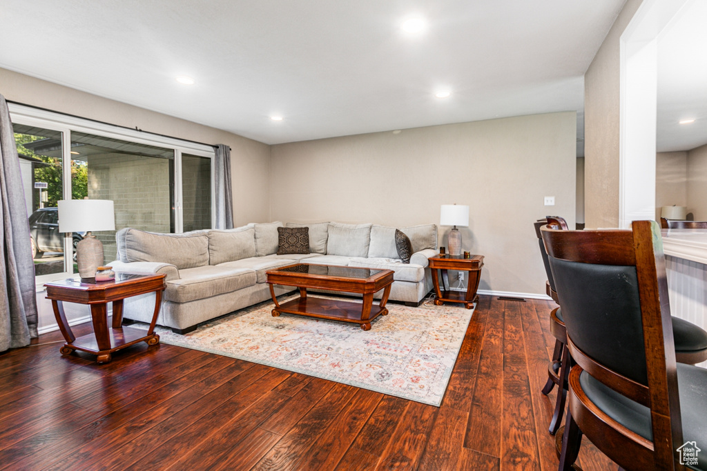 Living room with recessed lighting and dark wood-type flooring