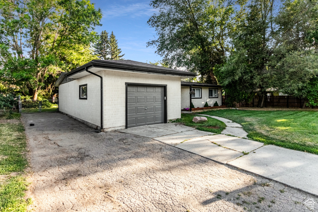 Garage featuring driveway and fence