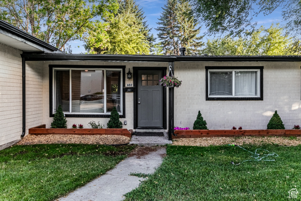 View of exterior entry featuring a yard