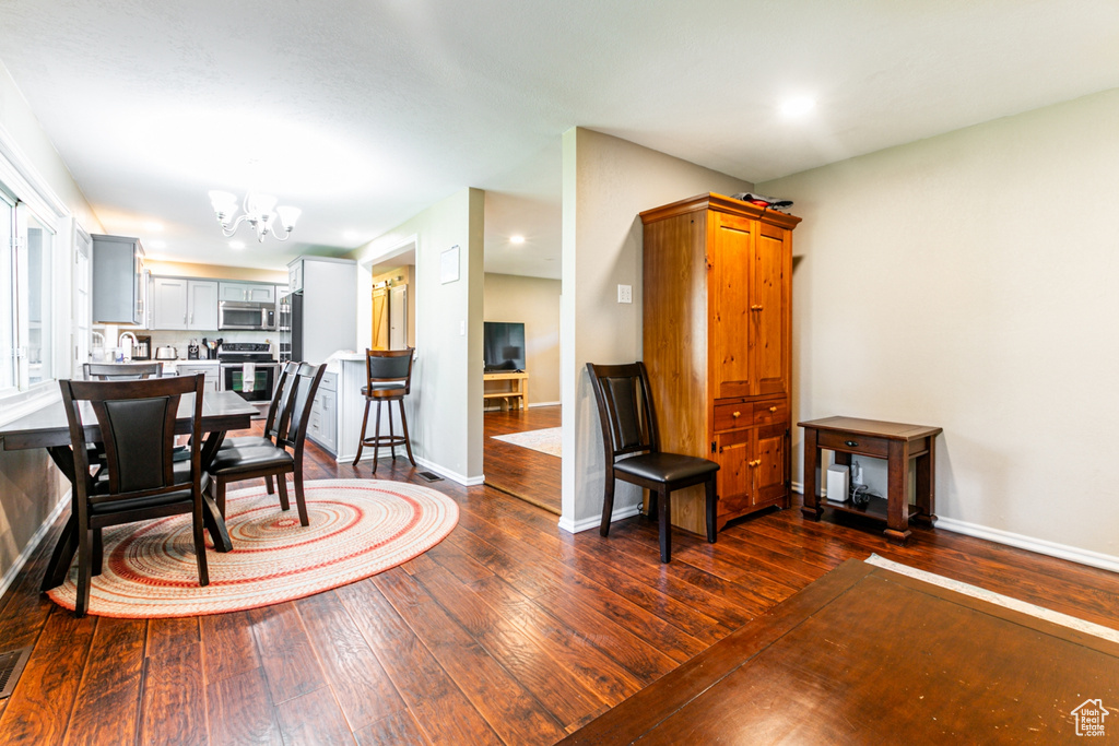 Interior space with baseboards, dark wood finished floors, a chandelier, and recessed lighting