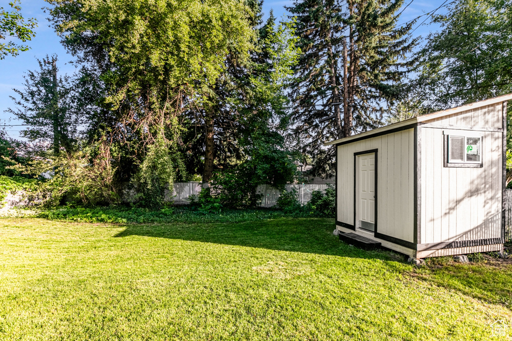 View of yard with an outbuilding, fence, and a storage unit