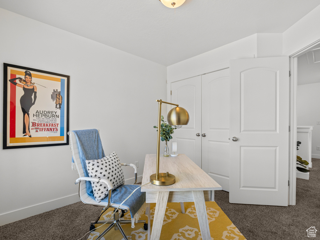 Carpeted home office featuring baseboards