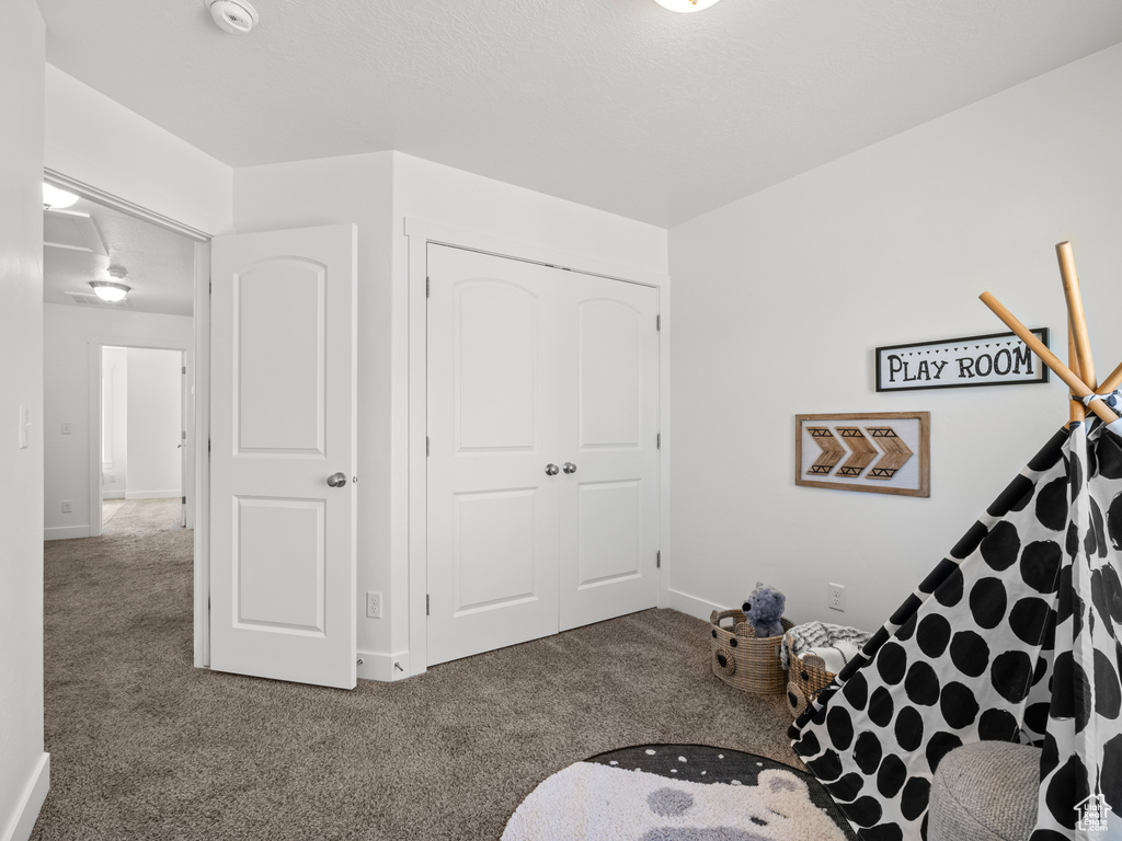 Game room featuring carpet and baseboards