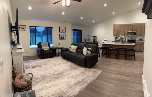 Living area featuring recessed lighting, ceiling fan, vaulted ceiling, and light wood finished floors