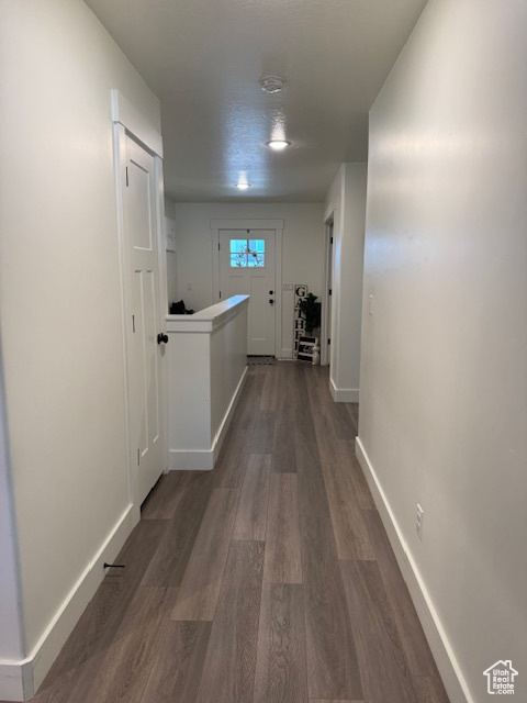 Hallway featuring baseboards and dark wood-style floors