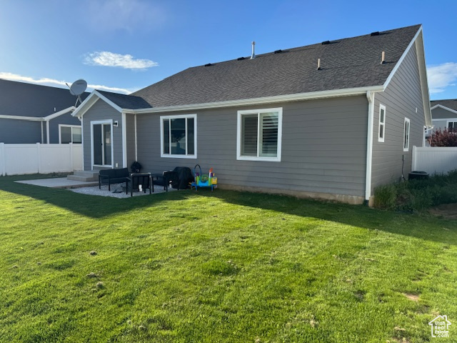 Rear view of house with a yard, a patio, fence private yard, and entry steps